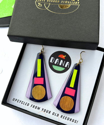 KAY in deep navy blue, neon pink, neon yellow, lilac, gold