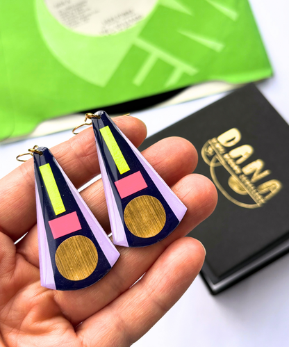 KAY in deep navy blue, neon pink, neon yellow, lilac, gold